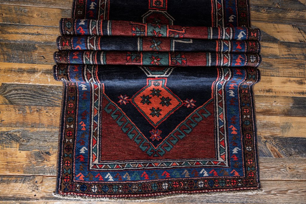 Semi-antique one-of-a-kind rug with dark red and navy tones