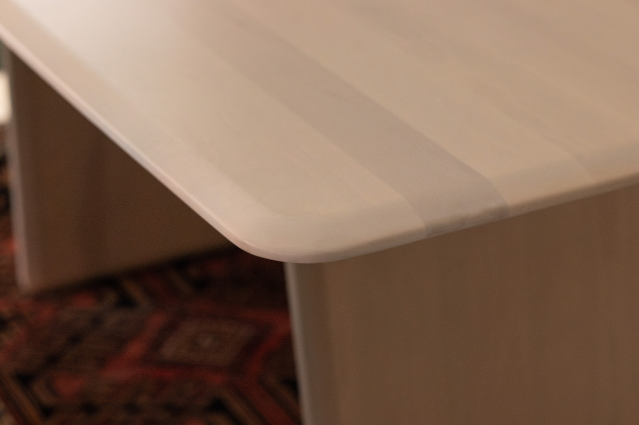 Close up detail photo of a Trica Volare Dining Table in a Blonde Ash Wood finish and rounded boat style edges.