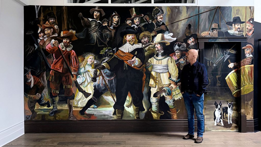 Robert Moore standing in front of his Night Watch mural in Saint John loft