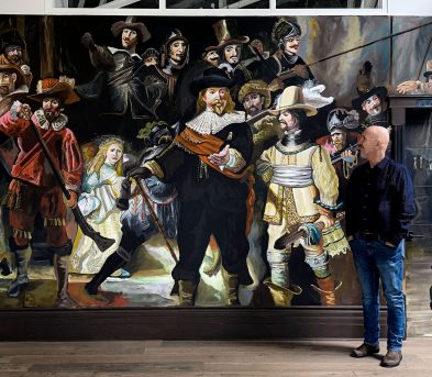 Robert Moore standing in front of his Night Watch mural in Saint John loft