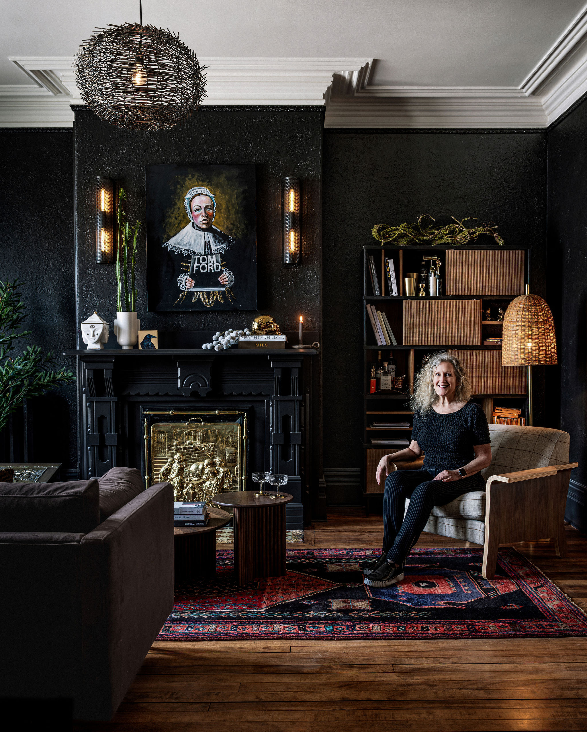 Judith Mackin sitting in the moody, atmospheric designed lounge at her boutique mid-term residence located in Saint John New Brunswick.